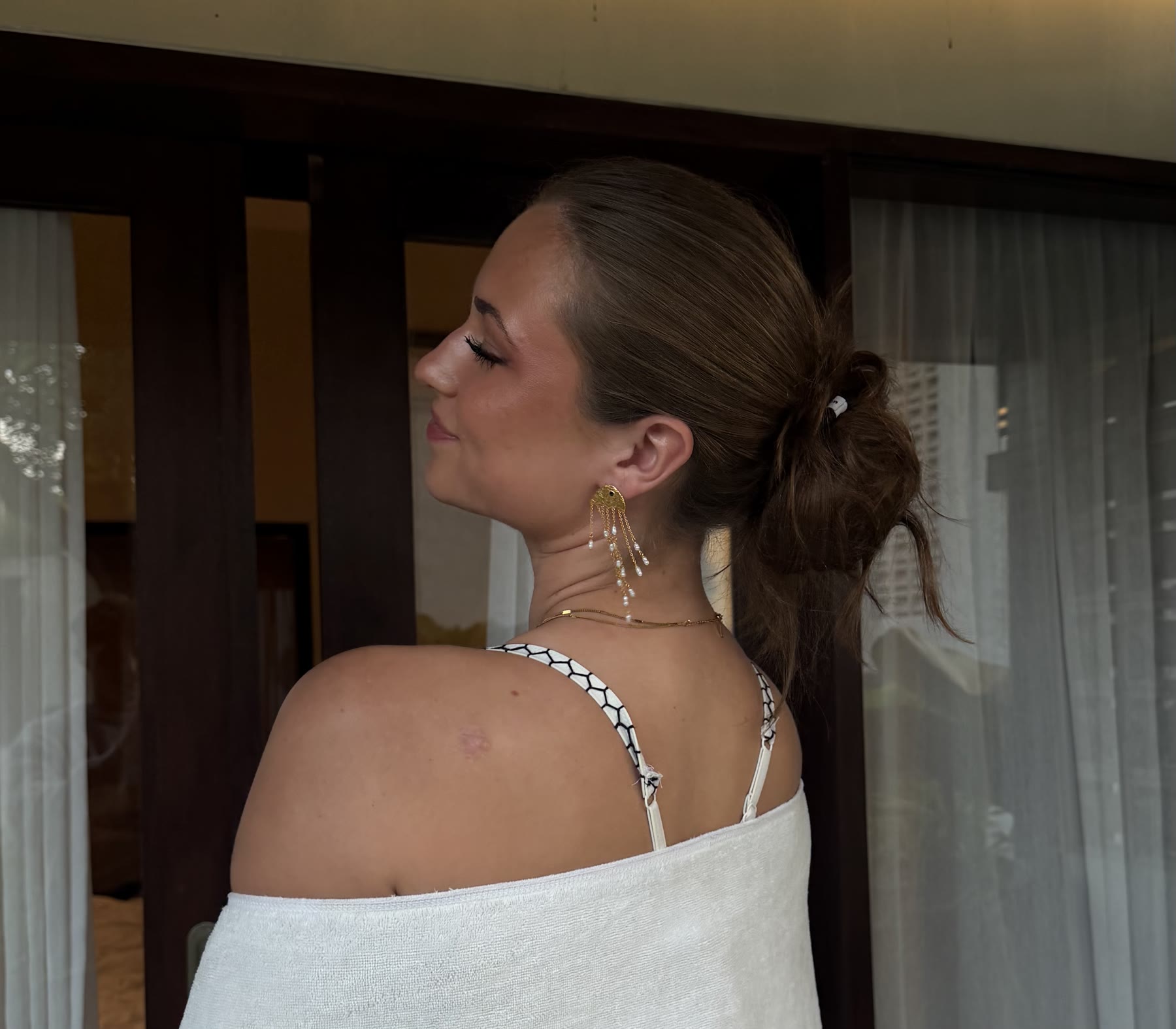 Julie smiling over her shoulder while wearing a towel